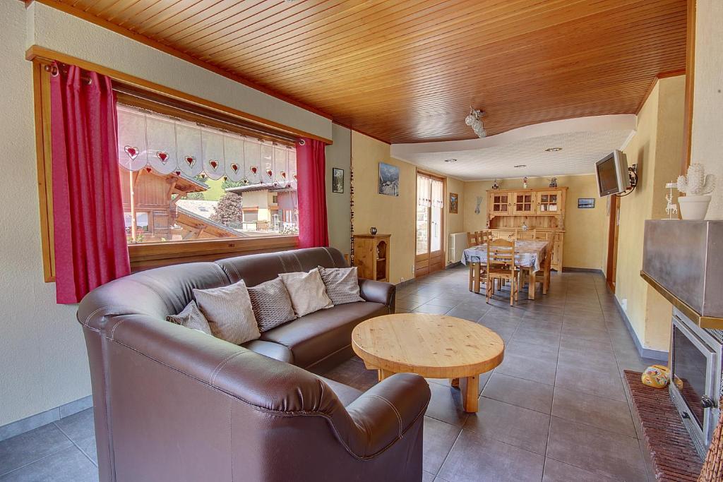 un salon avec un canapé en cuir et une table dans l'établissement GRAND APPARTEMENT - PROCHE DES REMONTEE MECANIQUES - MORZINE - 10 personnes - OUTO, à Morzine