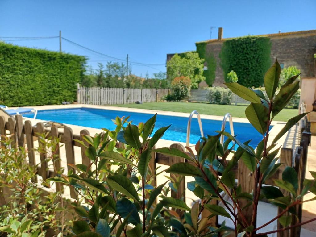 a swimming pool in a yard with a wooden fence at CAN PLANAS in Fonolleras