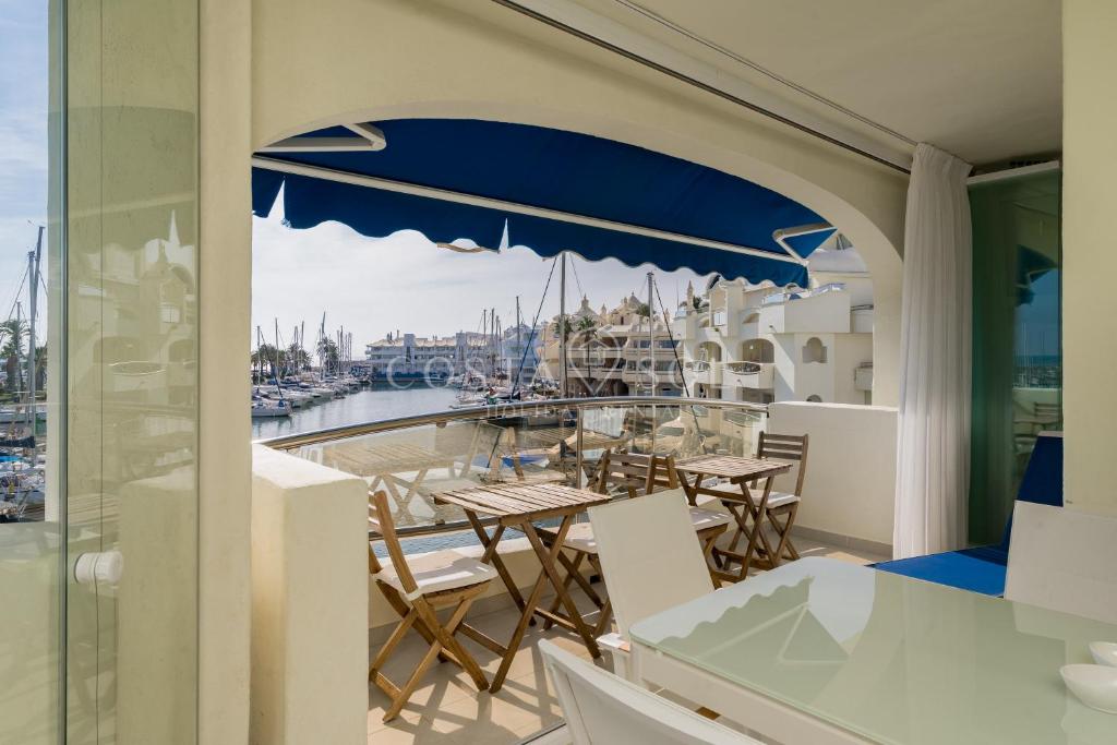 un balcone con tavolo, sedie e un porto turistico. di Benalmadena Costa Sol Holiday Rentals a Benalmádena