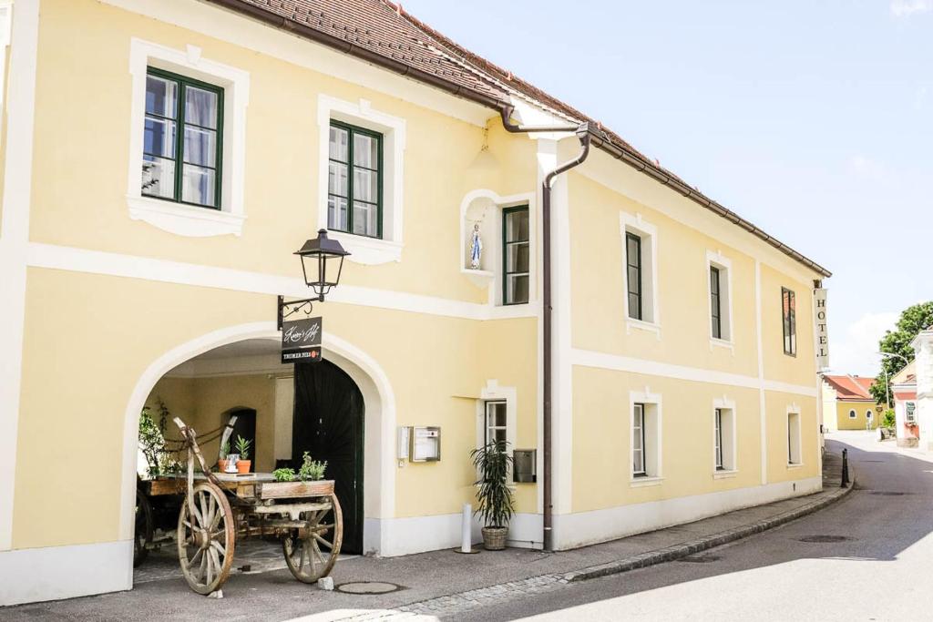 a yellow building with a horse drawn carriage outside at Kaiser's Hof in Strass