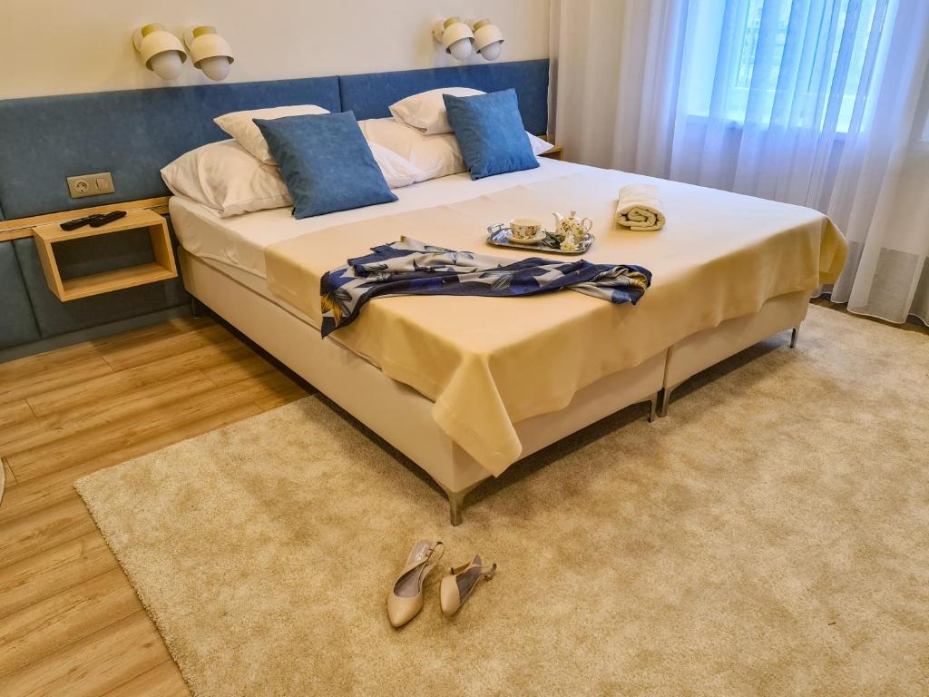 a bedroom with a large bed with shoes on it at Ditlin Apartmanok in Pápa