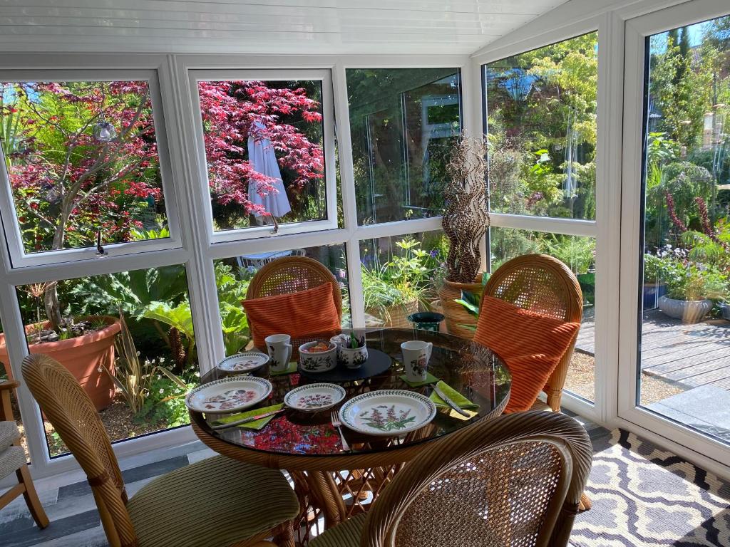 a dining room with a table and chairs and windows at The Peels B&B in Lowestoft