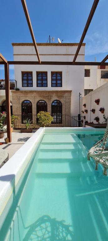 una piscina con una silla frente a un edificio en Murallas de Jayrán Hotel Boutique en Almería