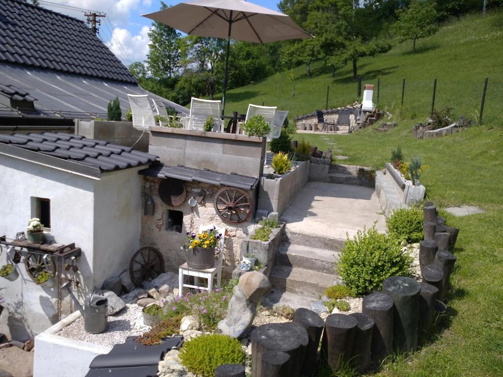 a backyard with a patio and an umbrella at Chalupa Ema Nikol in Rovensko pod Troskami