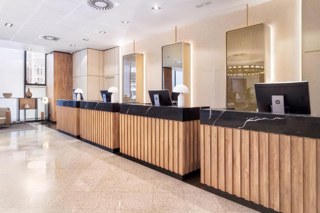 a hotel lobby with a reception desk with a tv at Melia Avenida de America in Madrid