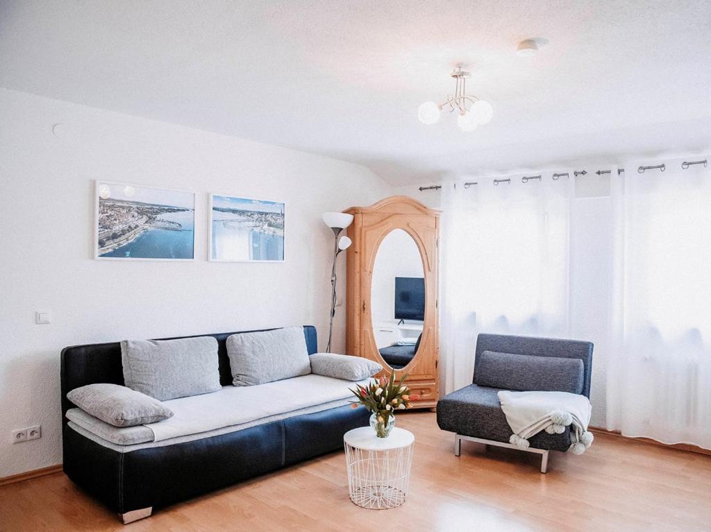 ein Wohnzimmer mit einem Sofa und einem Stuhl in der Unterkunft Ferienwohnung Auszeit am See in Moos