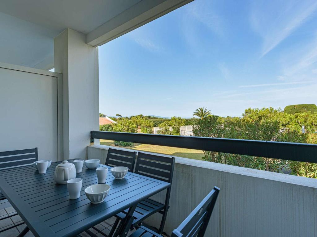 une table bleue sur un balcon avec vue dans l'établissement Aperçu mer: Bel appartement avec piscine, tennis et proche plage - FR-1-3-450, à Bidart