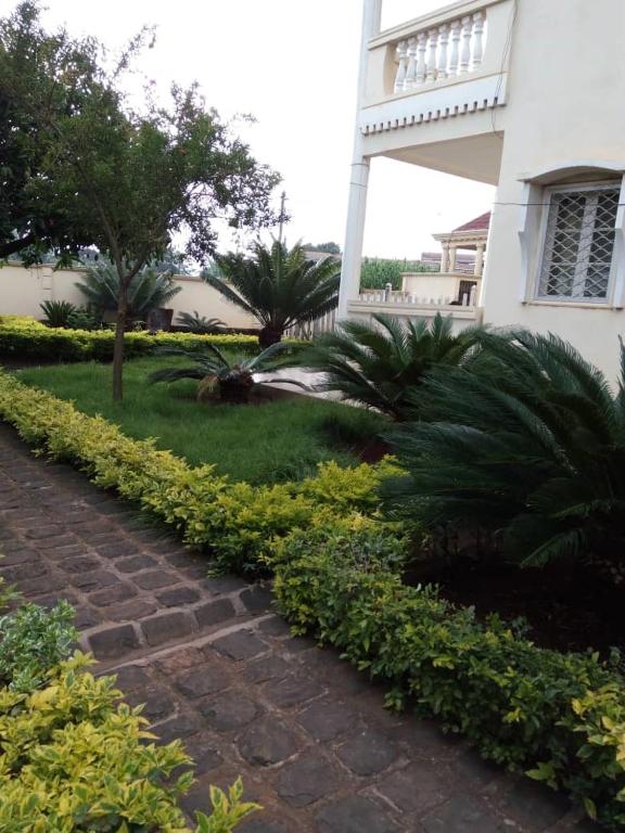 un sentiero in mattoni di fronte a una casa di MANOIR DES PRINCESSES BAFOUSSAM a Bafoussam