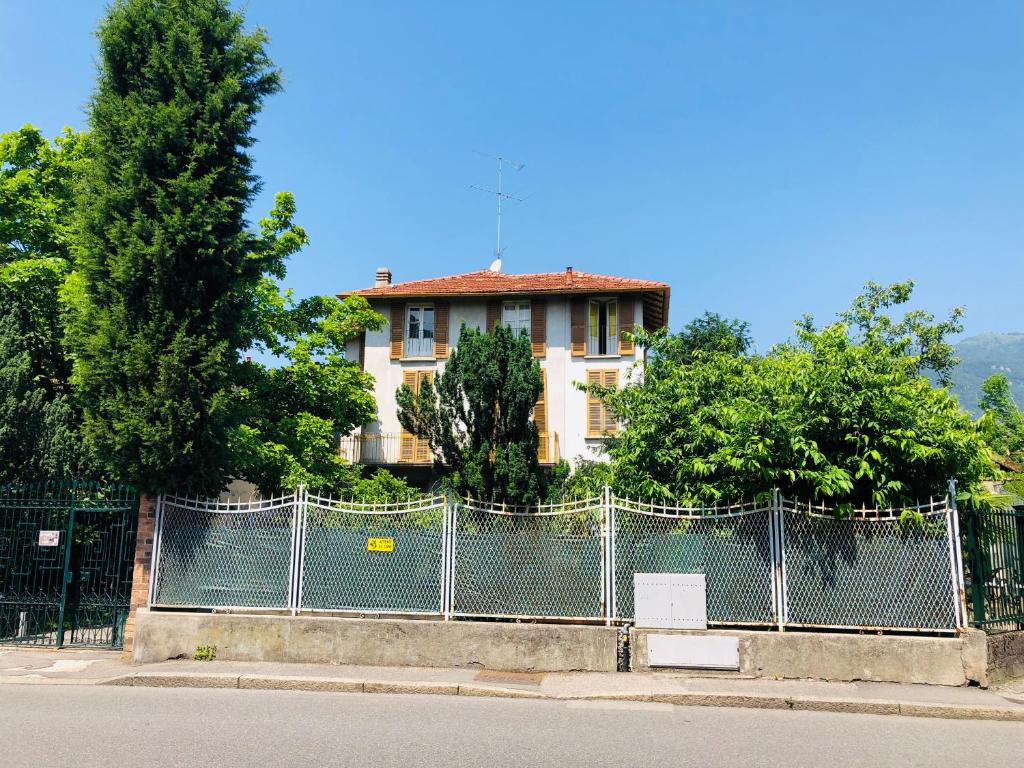 um edifício atrás de uma cerca em frente a um edifício em Casa di Aristide em Erba