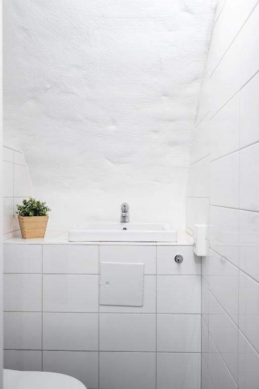a white bathroom with a sink and a toilet at Hotell Skeppsbron in Stockholm