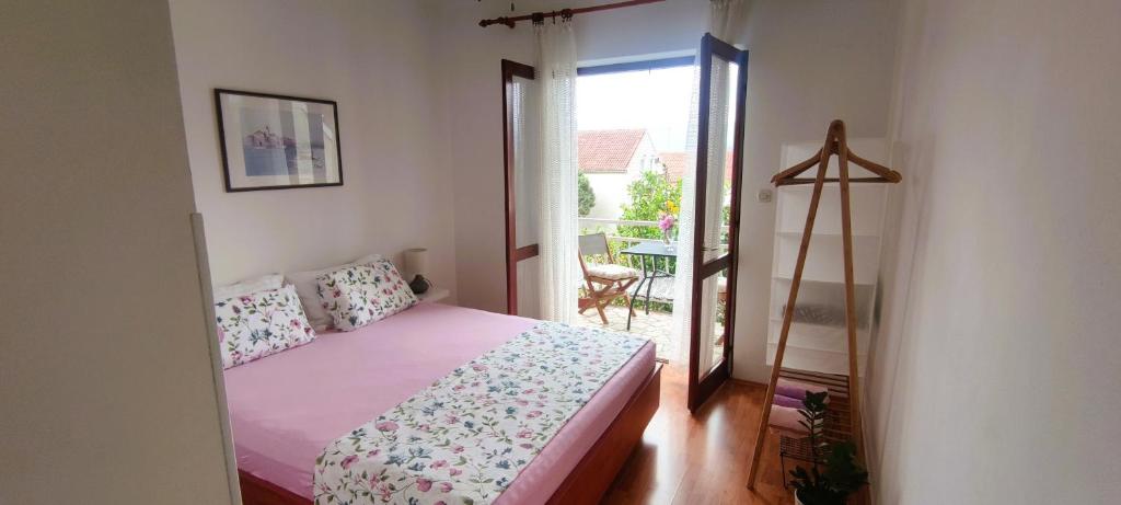 1 dormitorio con 1 cama y puerta a un balcón en Apartments Senka, en Viganj