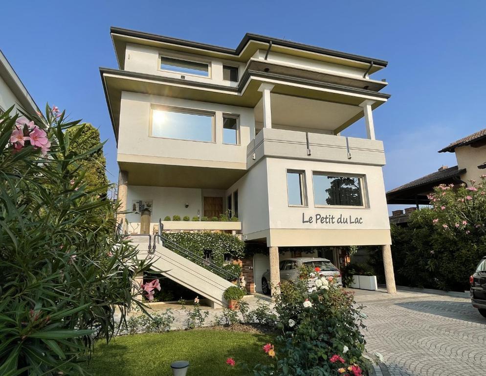 Una gran casa blanca con un cartel. en Le Petit Du Lac, en Sirmione