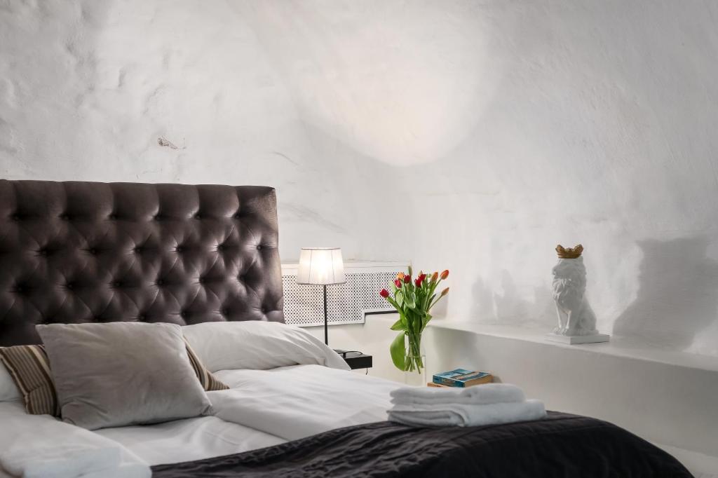 a bedroom with a large bed with a leather headboard at Hotell Skeppsbron in Stockholm