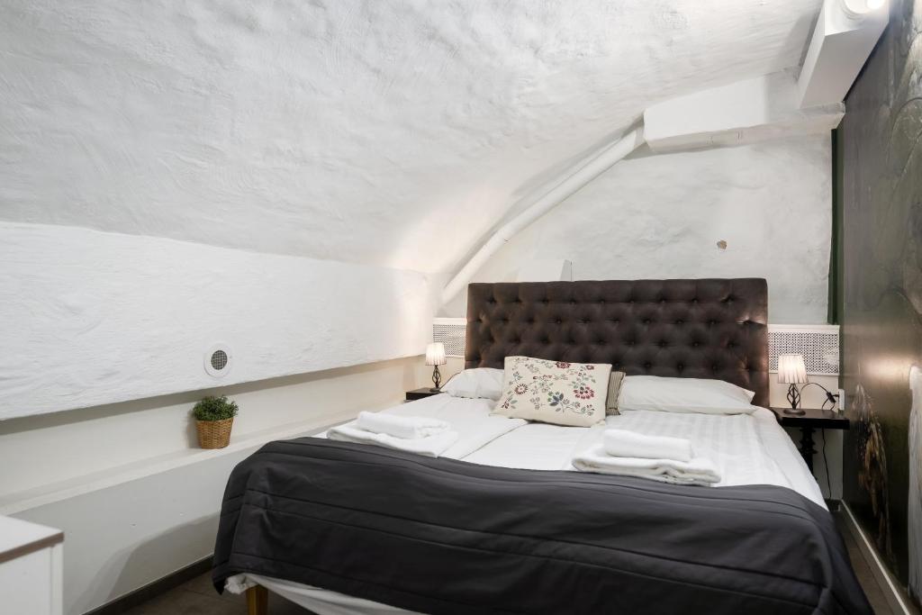 a bedroom with a large bed with white walls at Hotell Skeppsbron in Stockholm