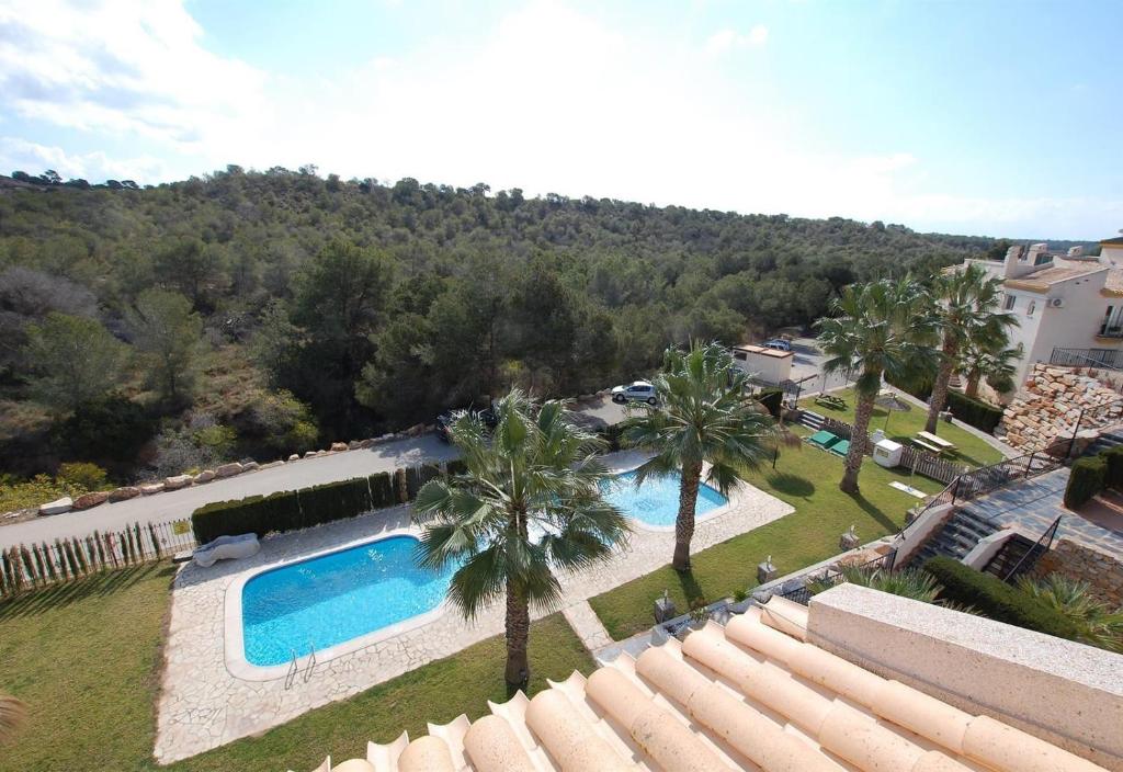 een uitzicht over een zwembad met palmbomen bij Nice apartment in a wonderful area in Villacosta