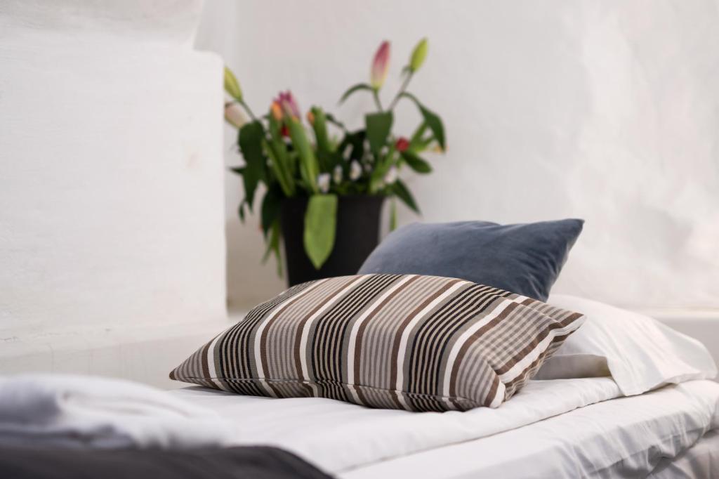 a pillow on a bed with a vase of flowers at Hotell Skeppsbron in Stockholm