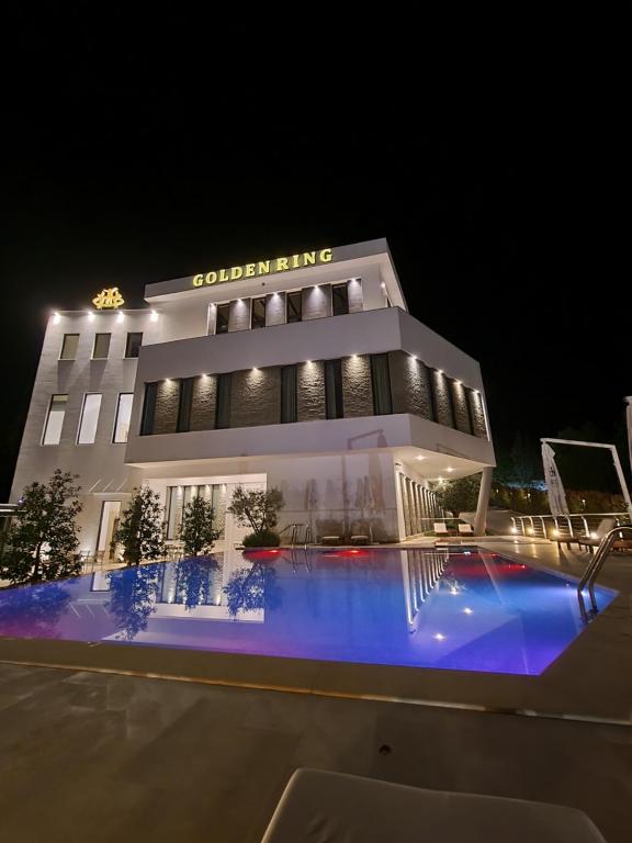 a hotel with a swimming pool at night at Golden Ring Resort in Tirana