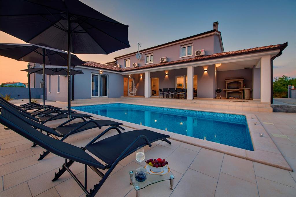 a villa with a swimming pool and a house at Villa MAAS in Loborika for 10 persons in Loborika