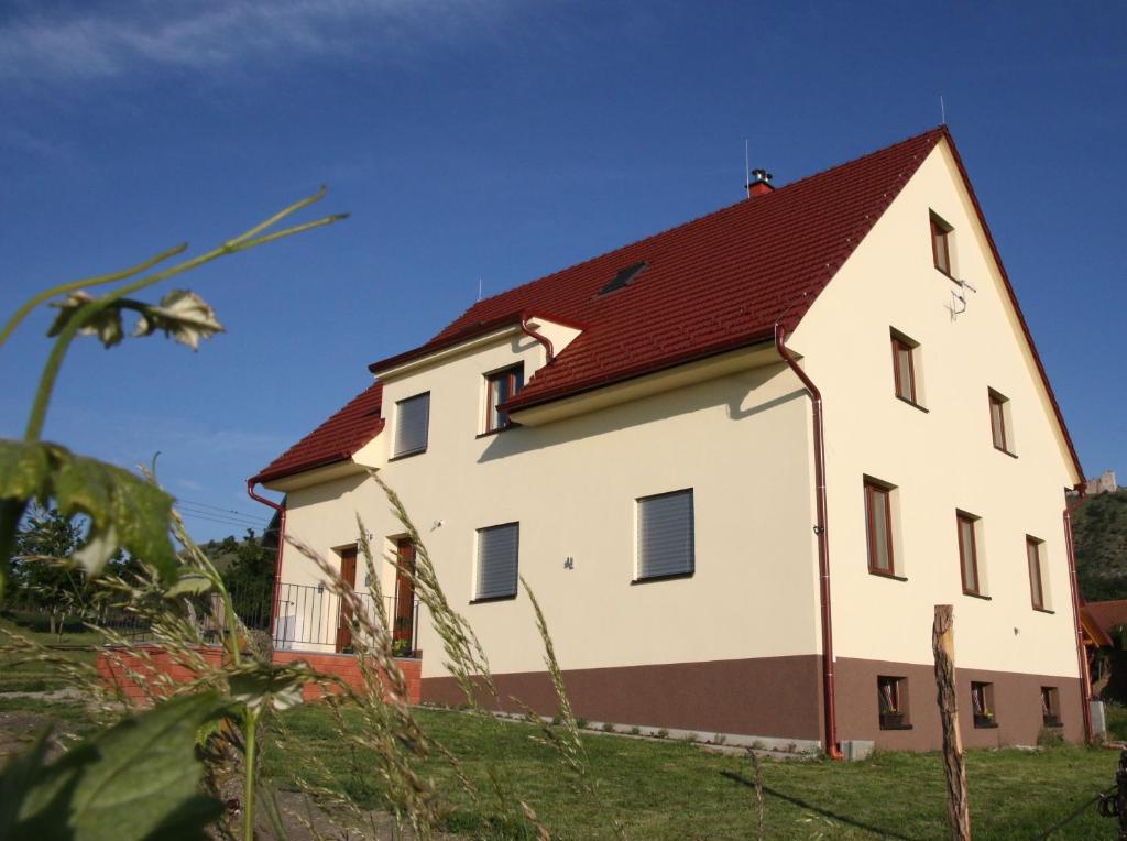 uma grande casa branca com um telhado vermelho em PALAVIA Apartments em Pavlov