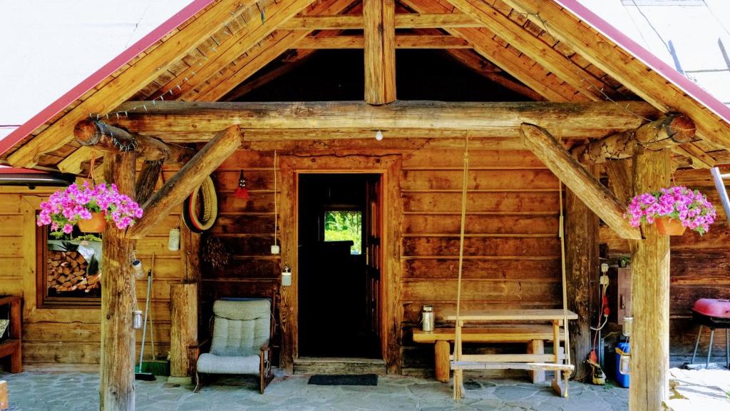 une cabane en rondins avec une porte, une table et des chaises dans l'établissement Chata pod Jaworem, à Wisła