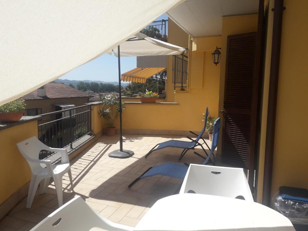 een balkon met witte stoelen en een parasol bij Casa Arena free parking in Bolsena