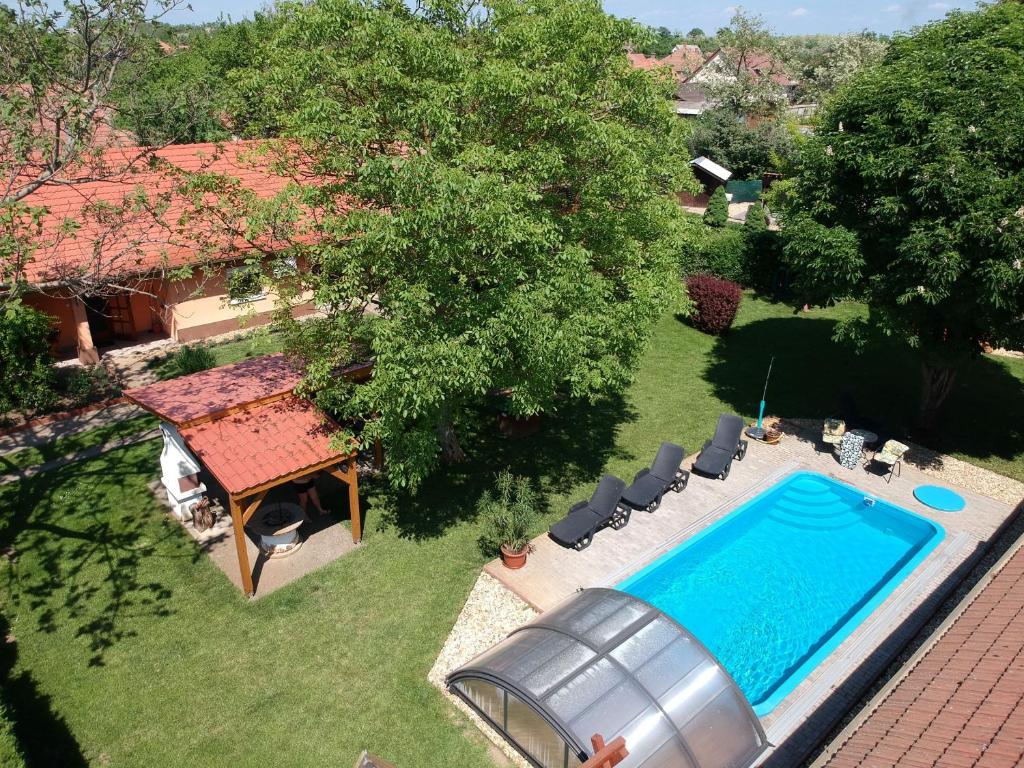 ティサフュレドにあるDiófa Vendégházakのプールと家のある裏庭の景色を望めます。
