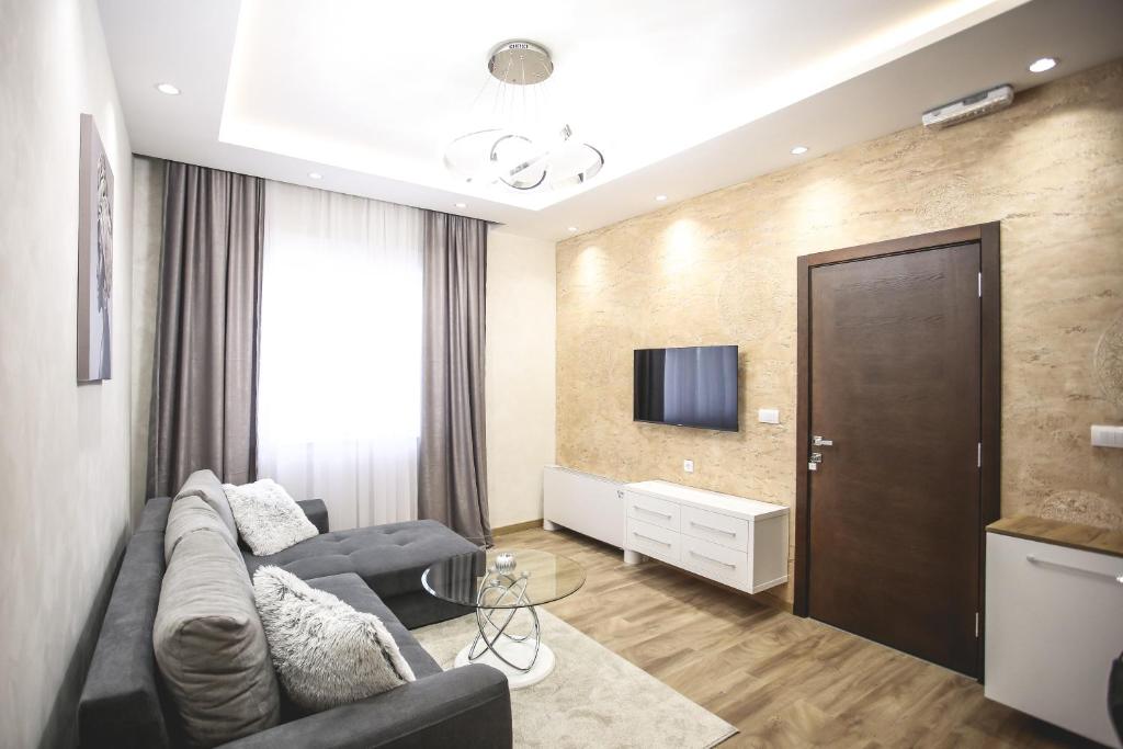 een woonkamer met een bank en een tv bij VILA MB in Ruma