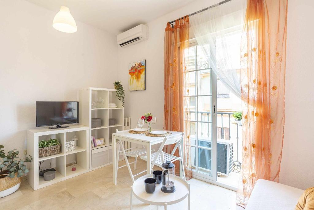 uma sala de estar com uma mesa e uma janela em Acogedor y céntrico apartamento em Málaga