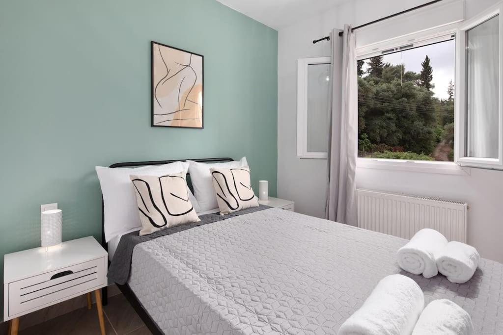 Un dormitorio con una cama con almohadas blancas y una ventana en Summer Moments Pool Villa en Evropoúloi