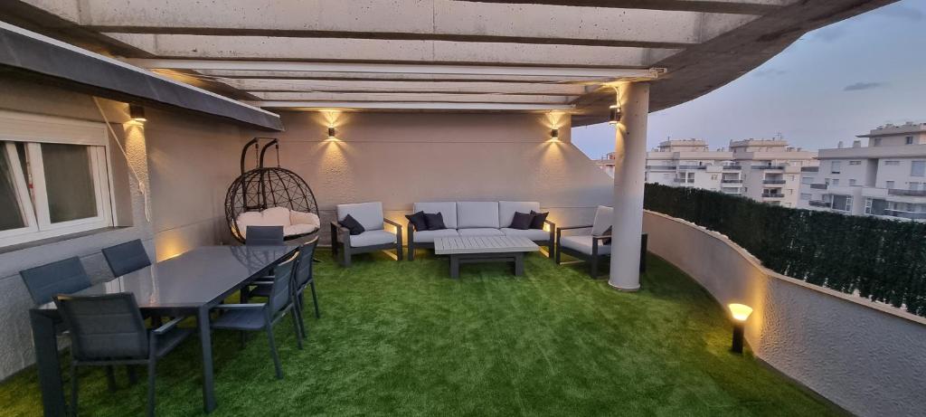 a patio with tables and chairs on a balcony at Ático ll Zona Veneziola in La Manga del Mar Menor