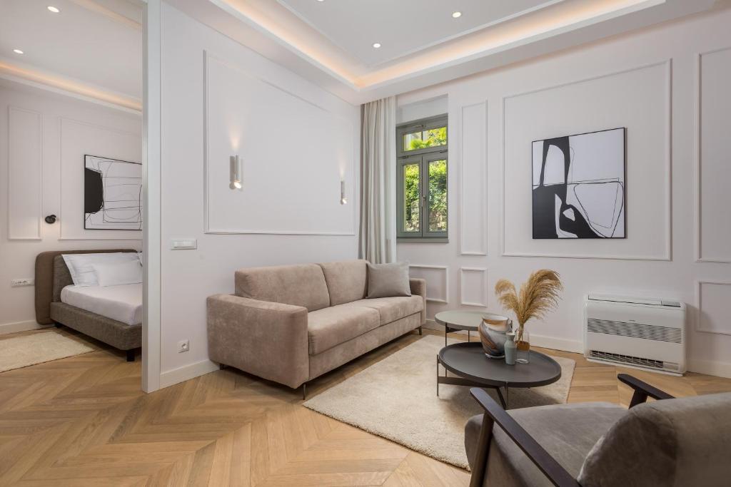 a living room with a couch and a bed at Plaza Apartments in Opatija