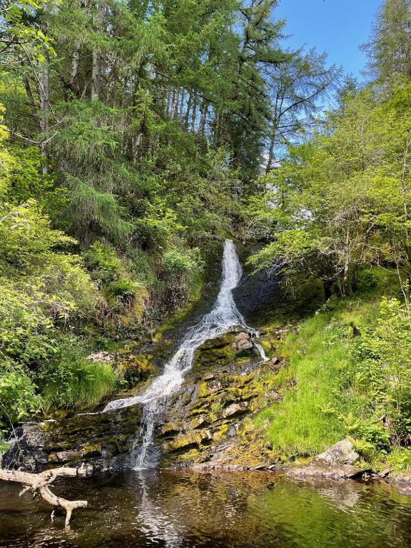 a waterfall on the side of a river at Y Felin Bed and Breakfast and Smallholding in Caersws