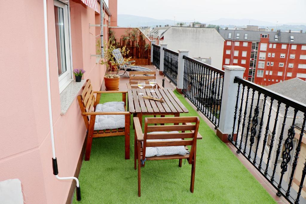 a balcony with a table and chairs on a balcony at ÁTICO DUPLEX CREDENCIAL in Sarria