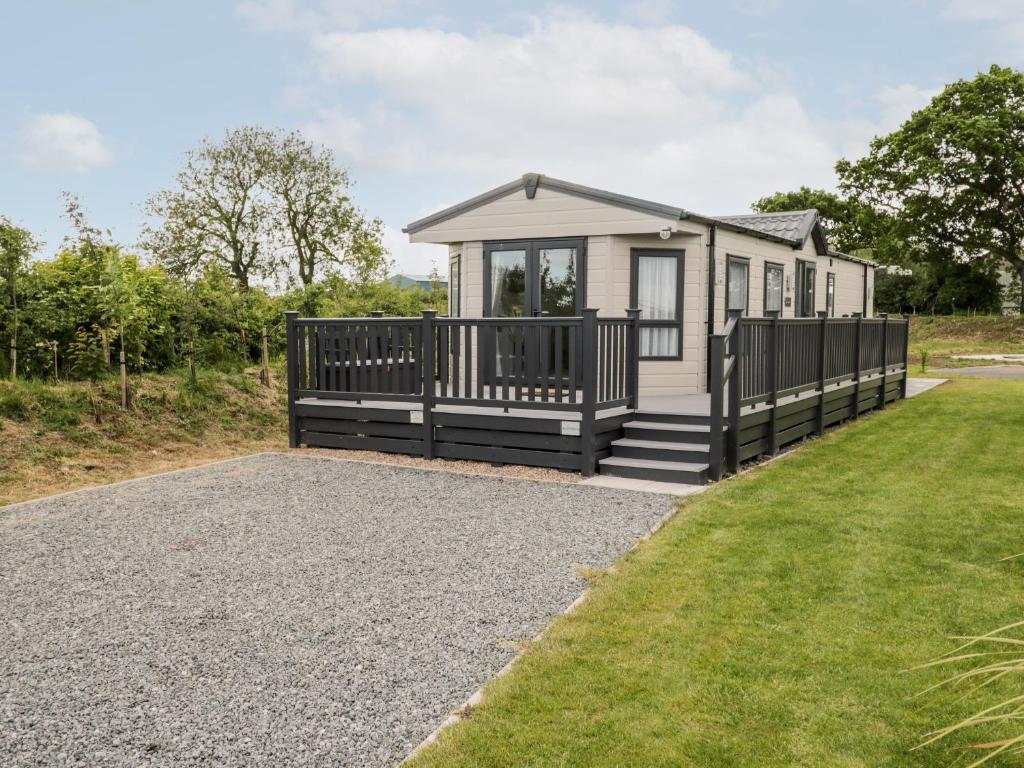 a tiny house with a porch and a lawn at Lazy Daze in Bridlington