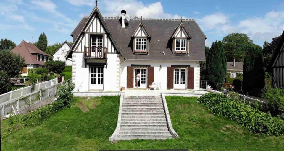 une grande maison blanche avec des escaliers en face de celle-ci dans l'établissement Villa Bonaparte, à Touques