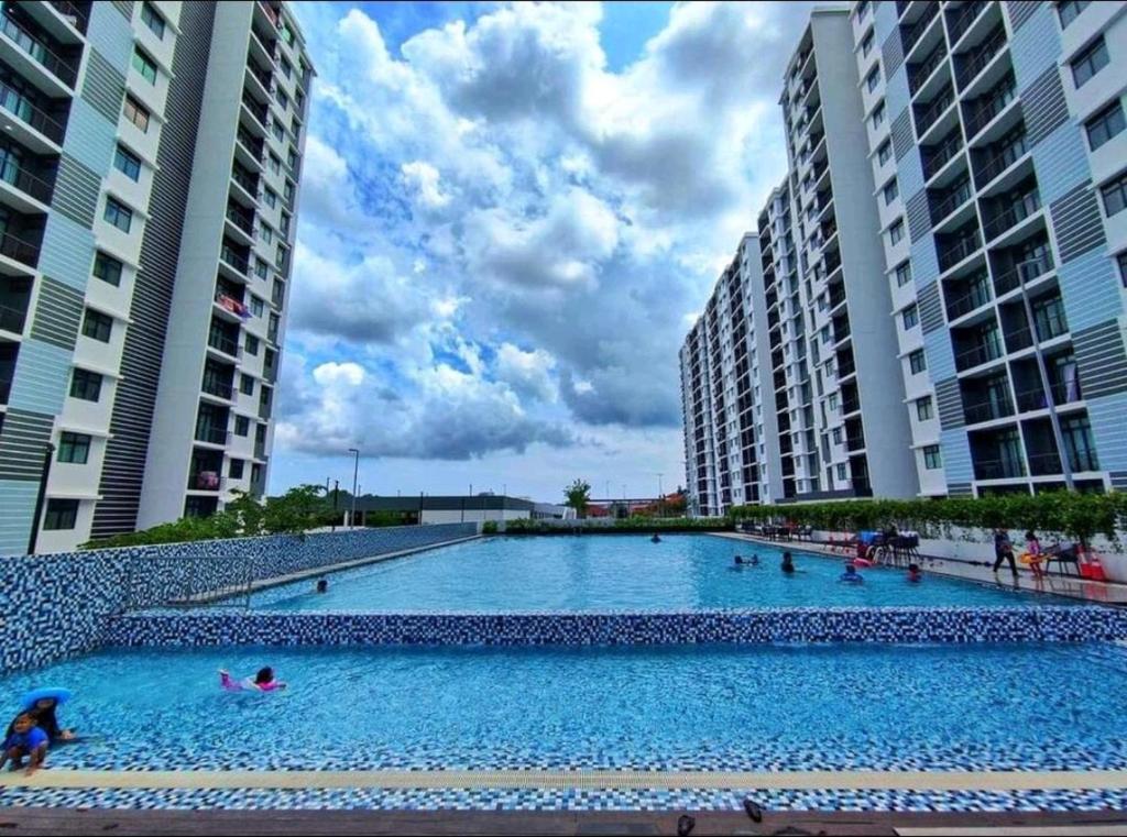 a large swimming pool between two tall buildings at Heritage Homestay in Kota Tinggi