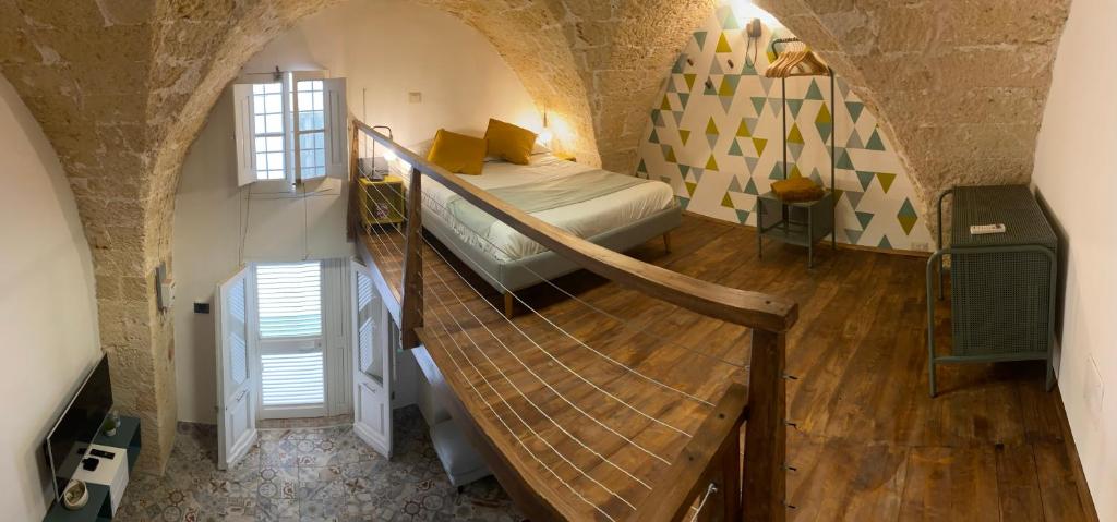 1 dormitorio con 1 cama y una escalera en una habitación en Casa Stella Salento - grazioso appartamento con 2 camere da letto nel cuore di Galatone, en Galatone