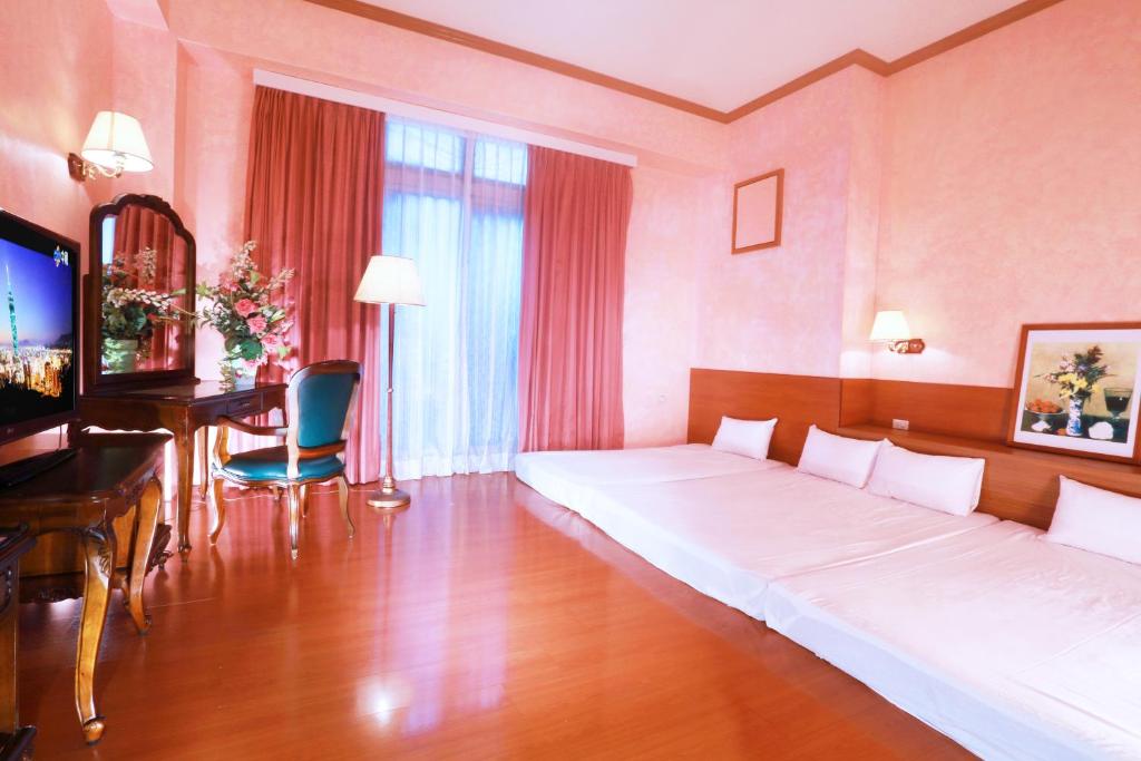 Habitación de hotel con cama grande y escritorio. en East Commercial Affairs Hotel en Luodong