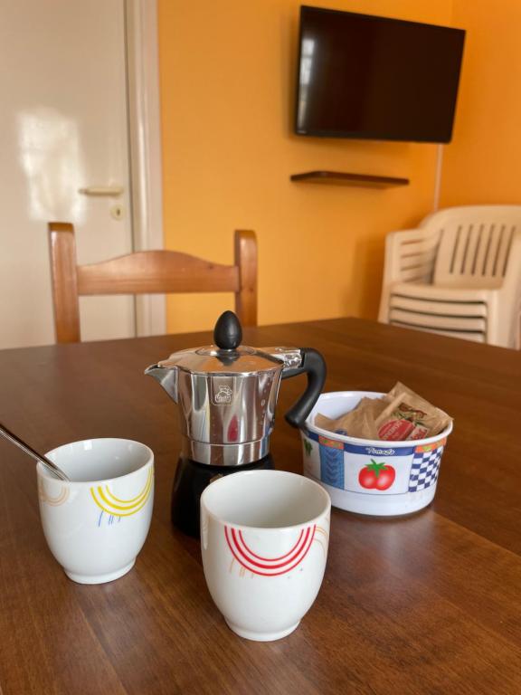 a tea pot and two cups on a table at Accogliente Appartamento Costa Makauda in Ribera