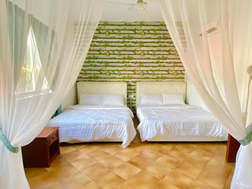 two beds in a bedroom with a brick wall at RumahChantiqq at Ehsan waterpark, Port Dickson in Port Dickson