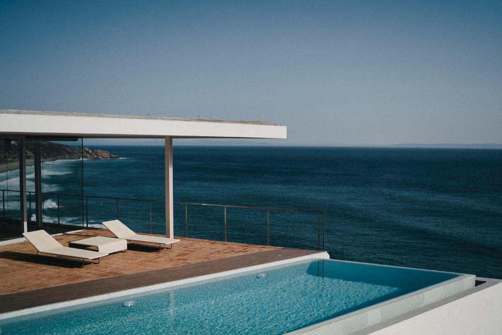 una piscina en la parte superior de una casa con el océano en Iris Zahara, en Zahara de los Atunes