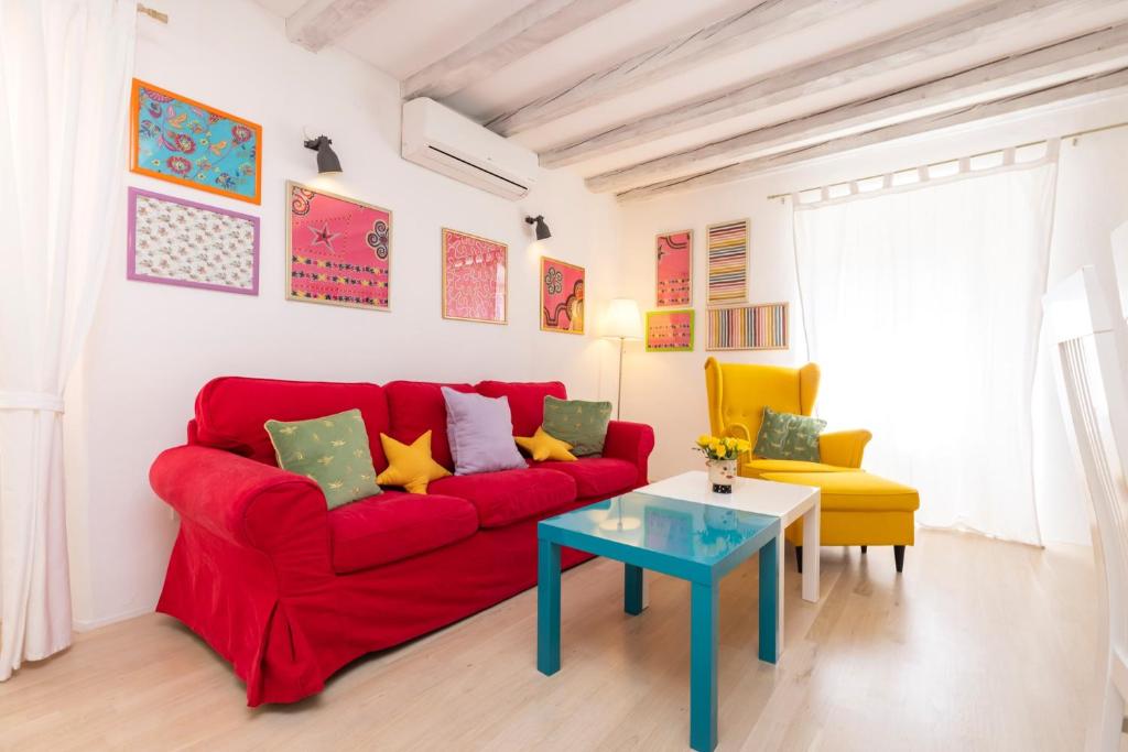 ein rotes Sofa und einen Tisch im Wohnzimmer in der Unterkunft House Encanto in Veli Lošinj