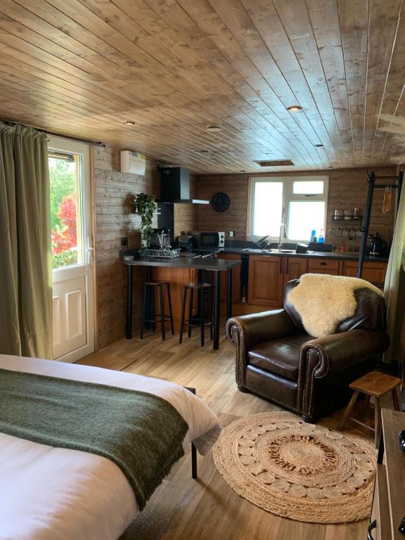 sypialnia z łóżkiem i krzesłem oraz kuchnia w obiekcie 1 bedroom woodland cabin w mieście Launceston