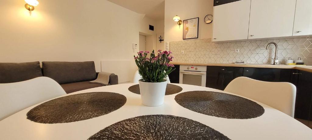 a kitchen with a table with a vase of flowers on it at Apartament Przy Bocznej in Kowary