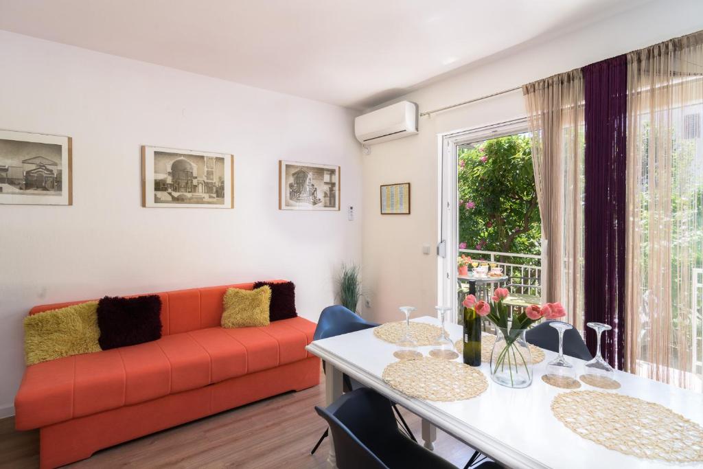 a living room with a red couch and a table at Apartments Mare Trogir in Trogir