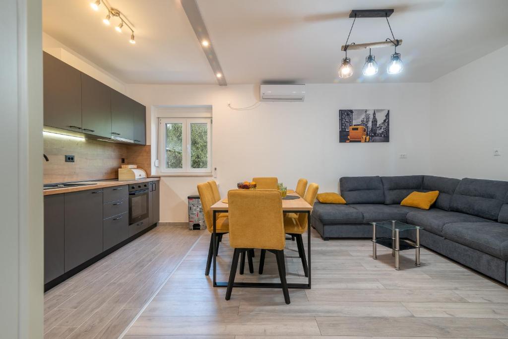 uma cozinha e uma sala de estar com uma mesa e um sofá em Apartman Galeb em Trogir