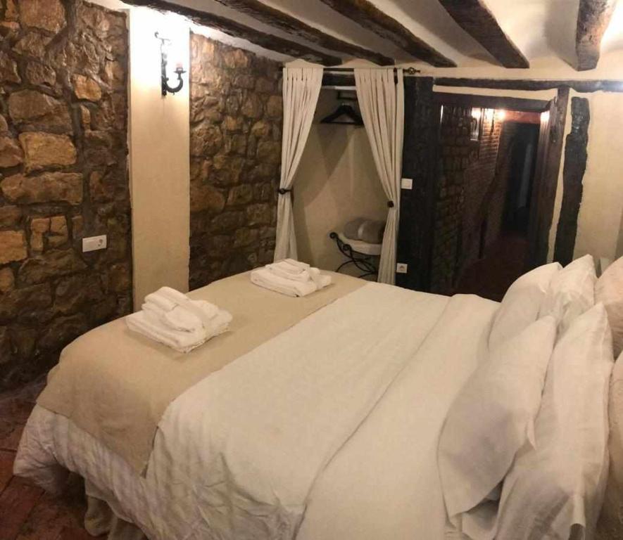 a bedroom with a white bed with towels on it at La Posada de Leza Your wine country getaway in Laguardia