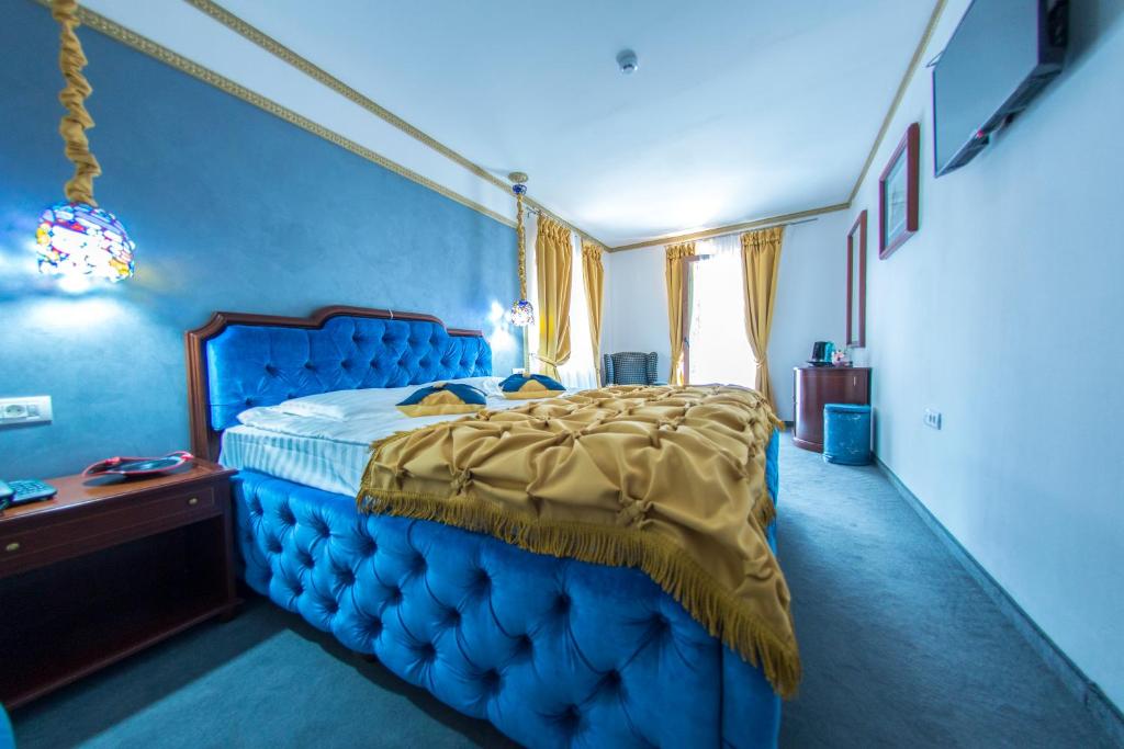 a blue bedroom with a bed with a blue head board at Voila Inn Predeal in Predeal