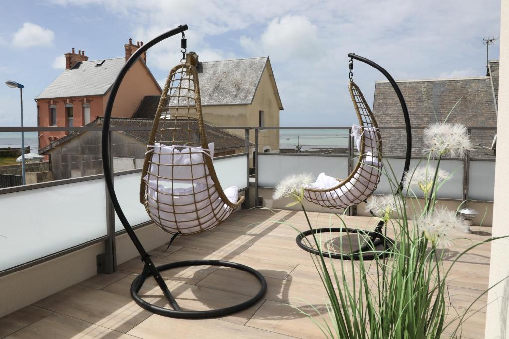 a balcony with two hammocks on a roof at Les Maisons de Louise in Pirou