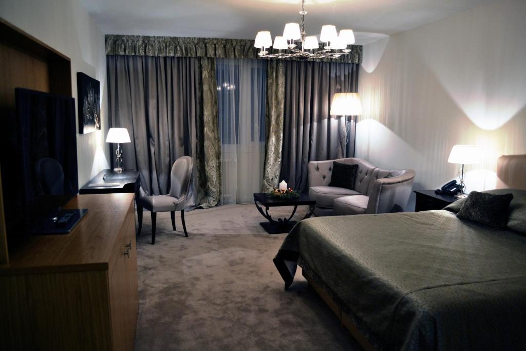 Habitación de hotel con cama y sala de estar. en Hotel Adriatica en Ginebra